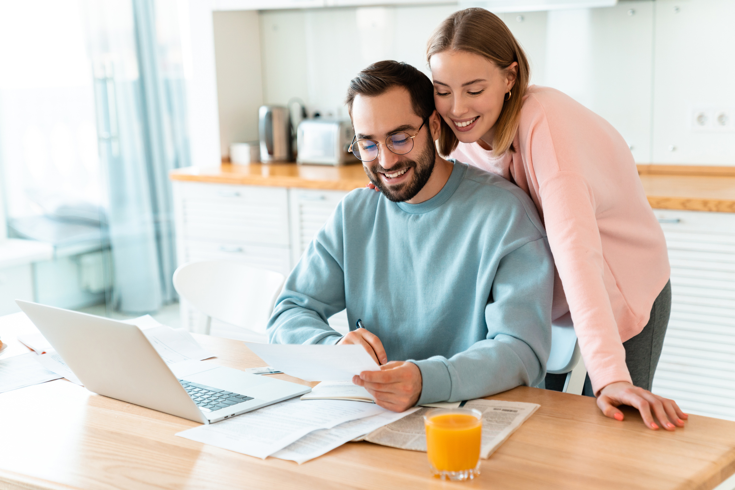 Couple reviewing household paperwork at a kitchen table