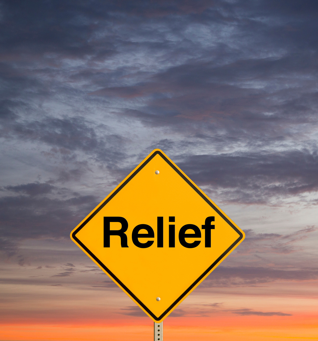 Road sign reading Relief against a sunset sky
