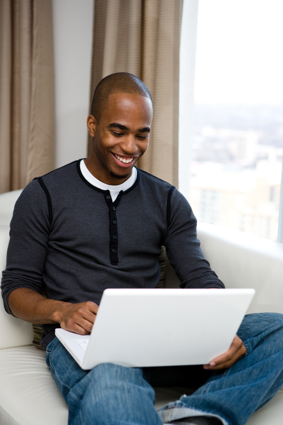 Smiling man working on a laptop