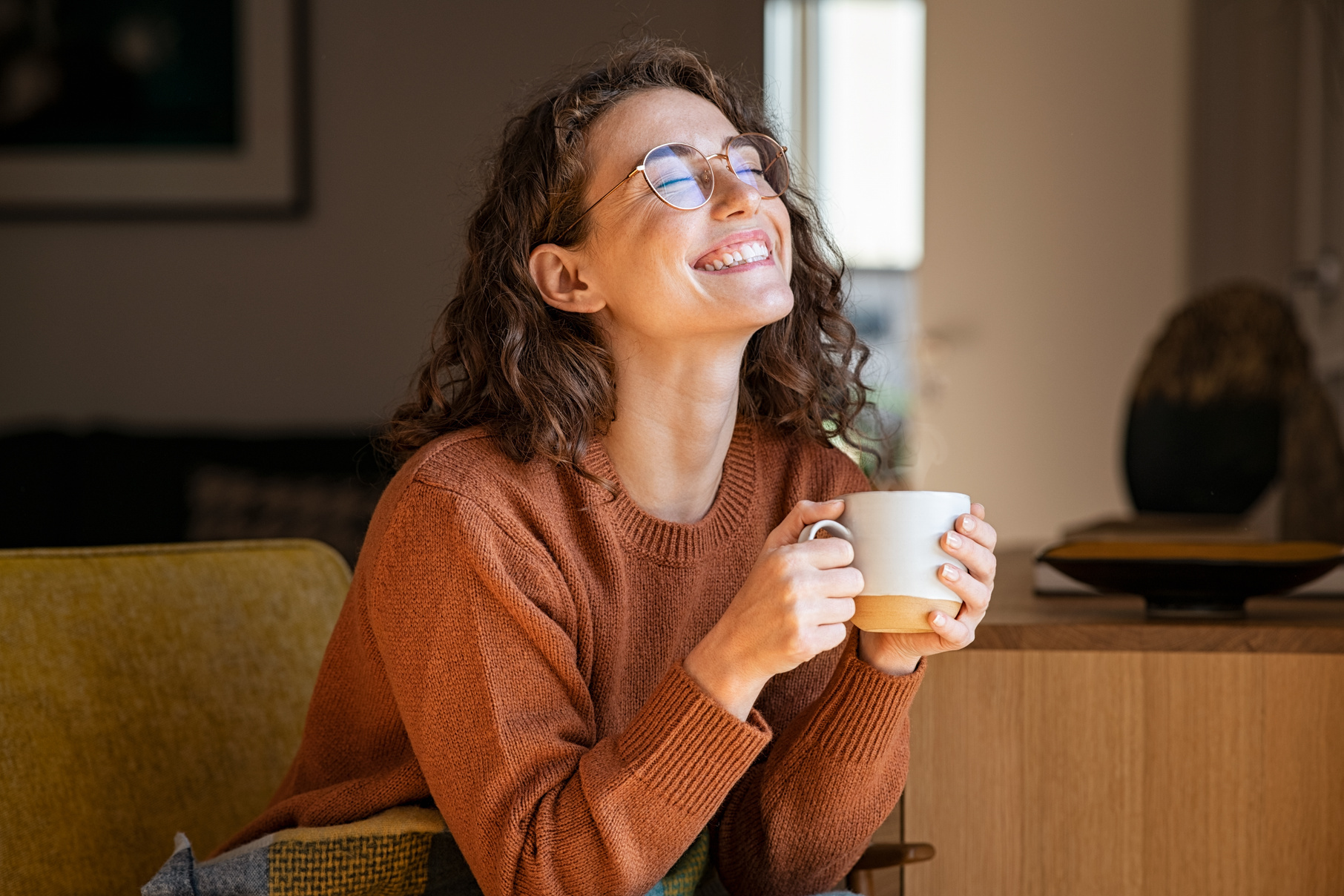 Woman smiling while holding a mug